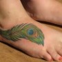 Tatuaggio piuma pavone sul piede