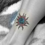 Foto tatuaggio sole sulla caviglia