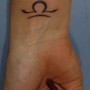 Piccolo tatuaggio simbolo bilancia interno polso