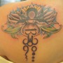 Simbolo della bilancia tatuato con un fior di loto