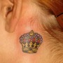 Piccola corona tatuata dietro orecchio
