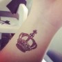 Simbolo corona reale tatuato interno polso