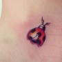 Tatuaggio coccinella con ali aperte