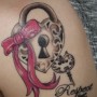Immagine tatuaggio lucchetto a forma di cuore con fiocco e chiave sulla spalla