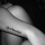 Life is beautiful citazione tatuata sul braccio