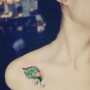 Piccola piuma di pavone colorata tatuata sulla spalla
