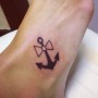 Piccolo tatuaggio fiocco con ancora sul piede