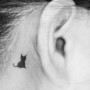 Piccolo tatuaggio gatto nero dietro orecchio