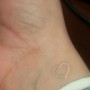 Piccolo cuore tatuato con inchiostro bianco interno polso