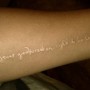 White ink tattoo con scritta sul braccio
