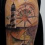 Tatuaggio di un faro con rosa dei venti