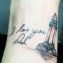 Tatuaggio piccolo faro con dedica